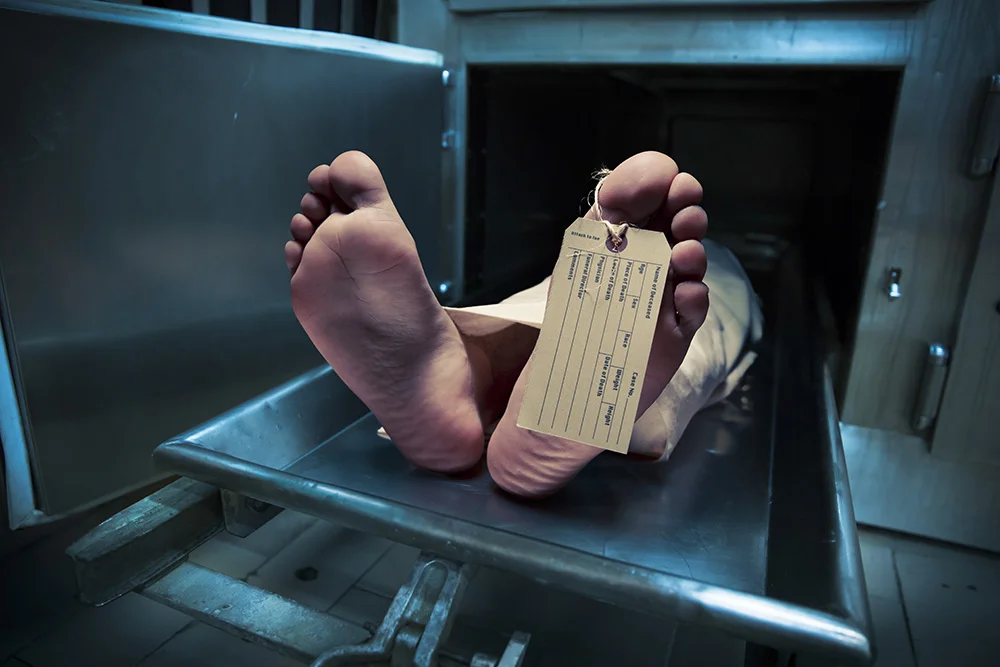 Grungy photo of feet with toe tag on a morgue table