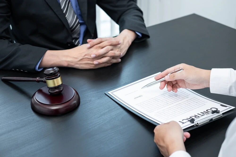 Professional Male lawyer or counselor discussing negotiation legal case with client meeting with document contract in office