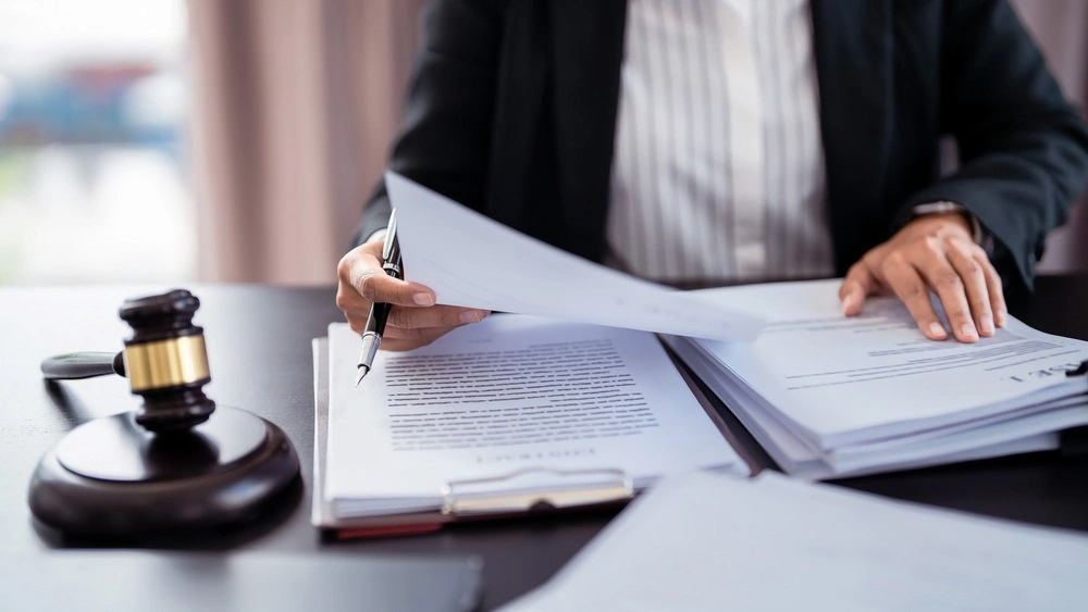 Lawyer businesswoman holding document to reading lawsuit and checking about financial business data while analysis
